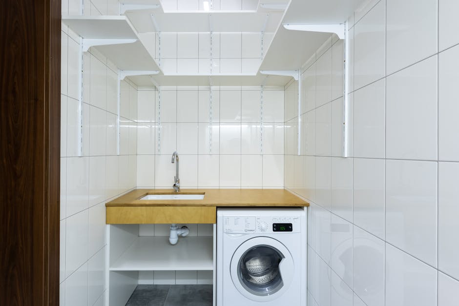 minimalist wooden laundry room with integrated appliances