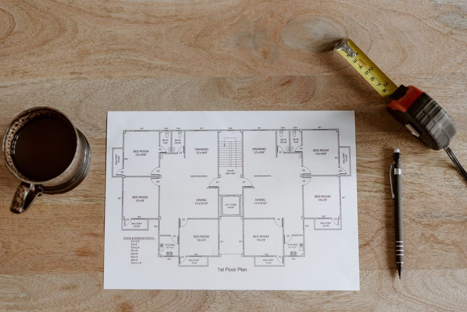minimalist architectural blueprints on wooden table with coffee