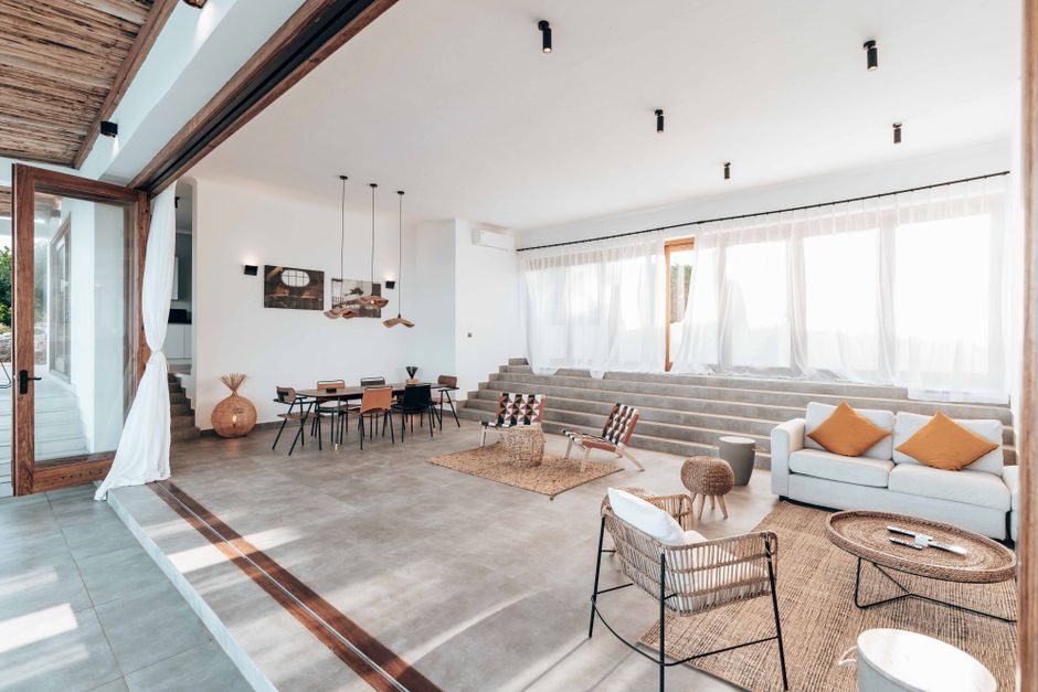minimalist open plan living room with natural wood furniture and large windows