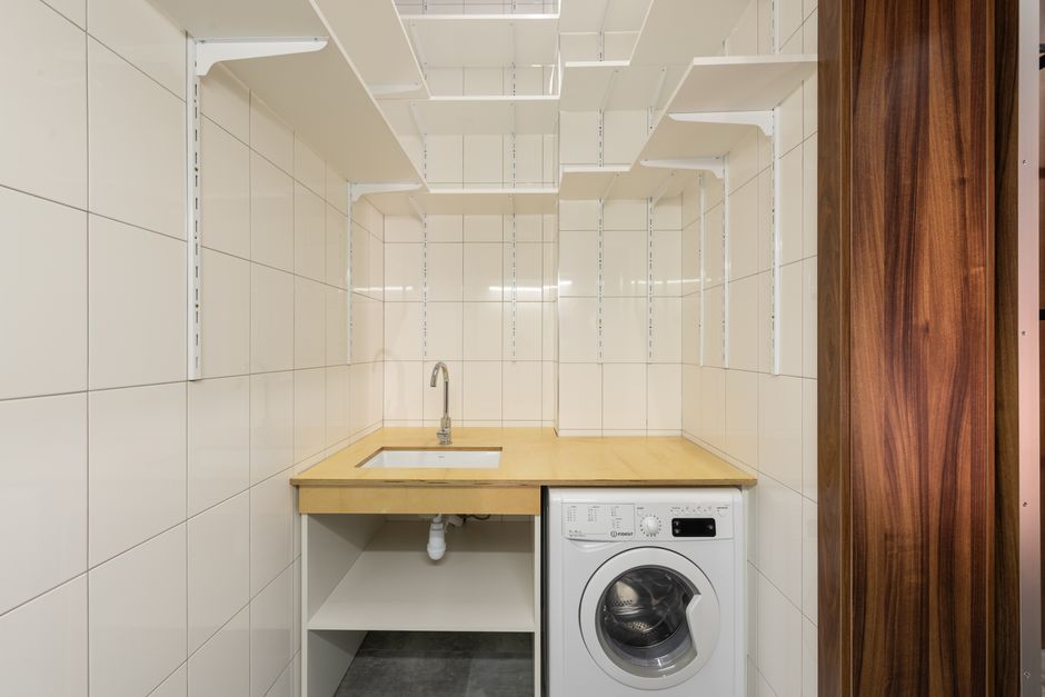 bright minimalist laundry room with wooden shelves and natural light