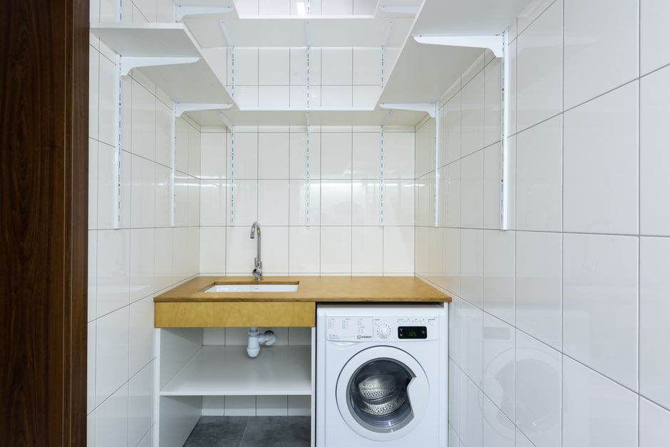 organized modern laundry room with wooden shelving
